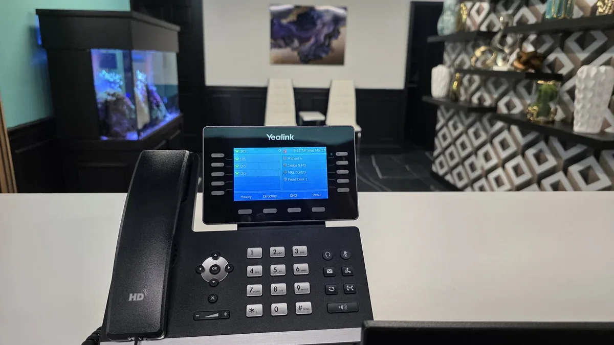 Yealink IP desk phone with active multi-line display showing extensions — TSS USA commercial phone system installation.